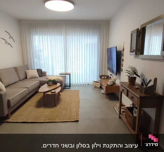 וילון לבן שקוף תלוי על חלון גדול בסלון